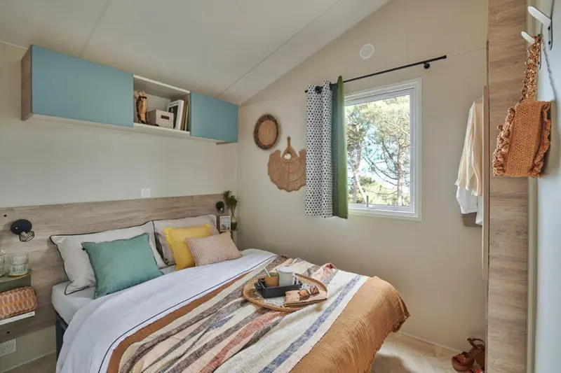 Une chambre lumineuse avec un lit double et une décoration soignée.