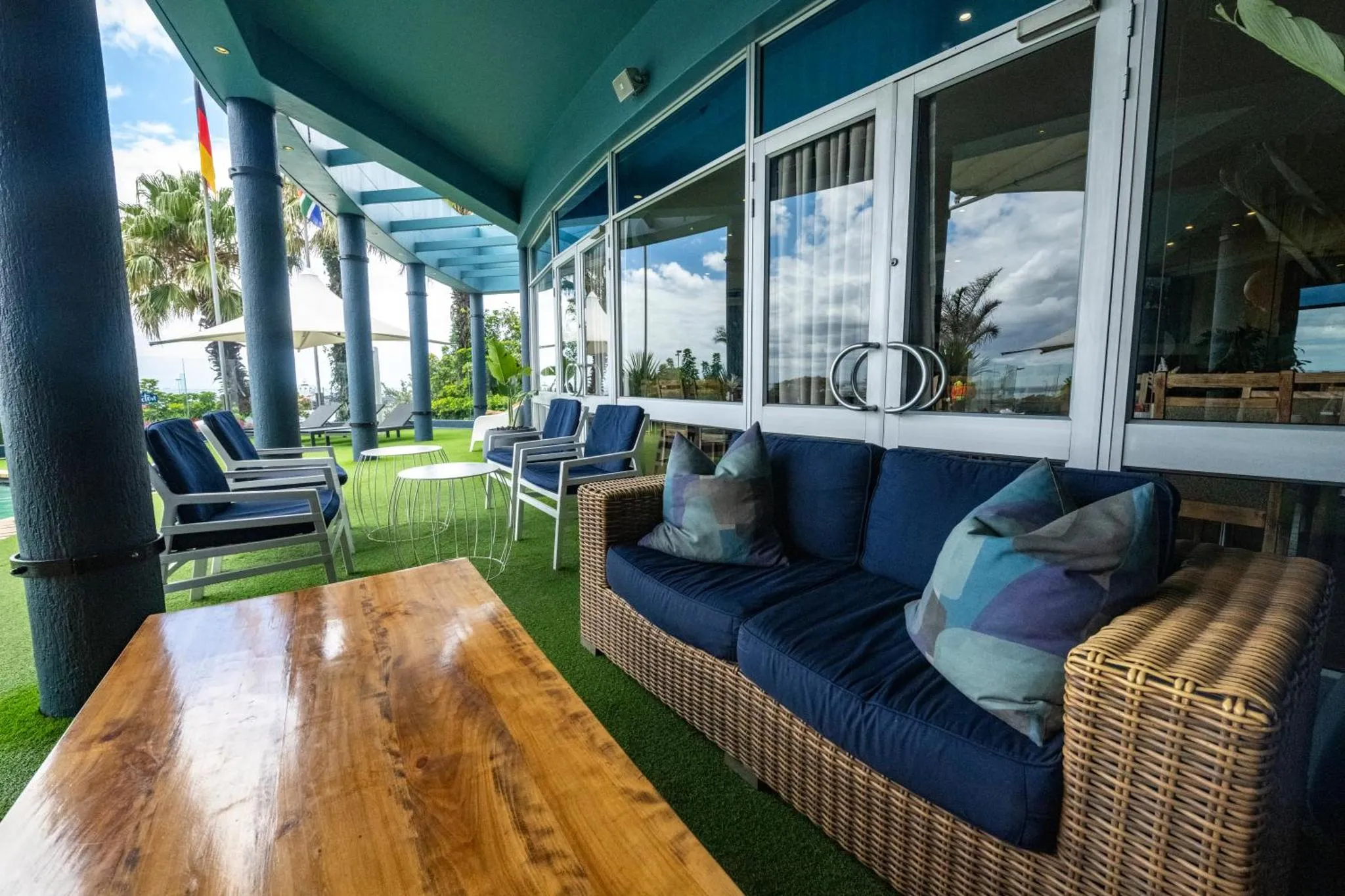 Espace de détente extérieur avec canapés et tables basses sur une terrasse.