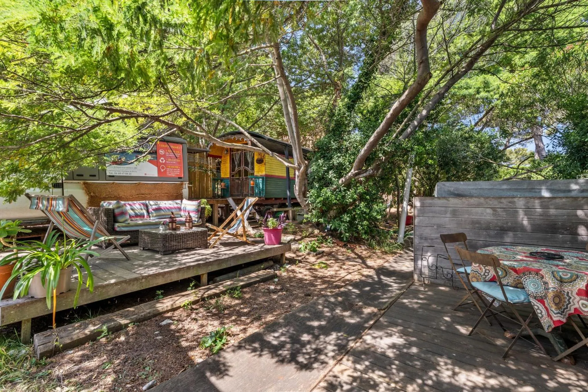 Terrasse en bois avec mobilier de jardin et espace détente ombragé.