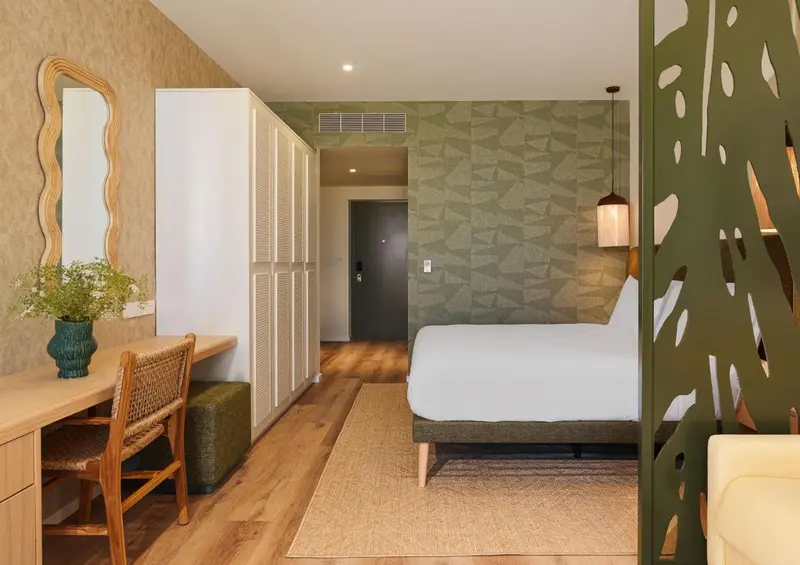 Une chambre lumineuse avec un lit et un espace bureau.
