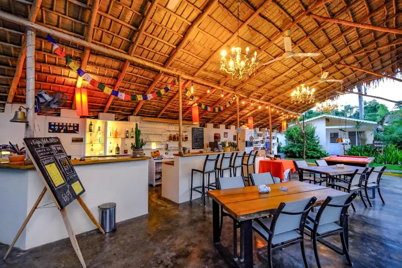 Une salle à manger ouverte avec un bar et des tables en bois.