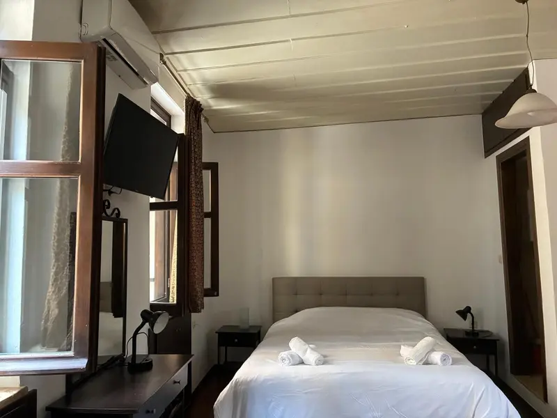 Une chambre lumineuse avec un lit et une fenêtre.
