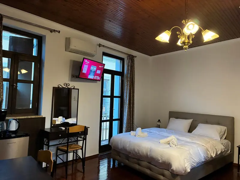 Une chambre lumineuse avec un lit double et un coin coiffeuse.
