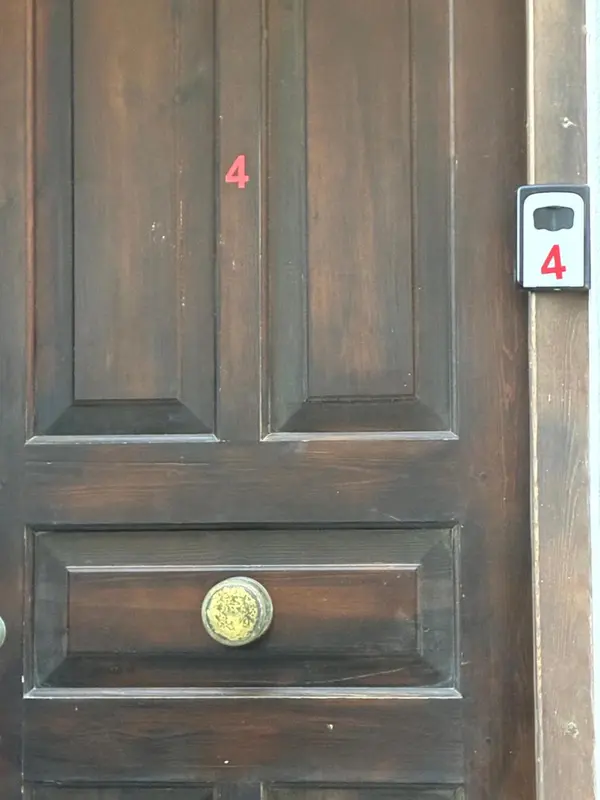 Porte en bois brun avec poignée dorée et numéros.