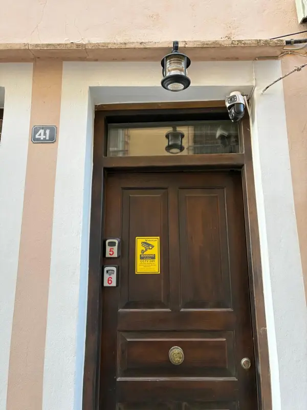 Une porte d'entrée en bois brun avec des numéros et des autocollants.