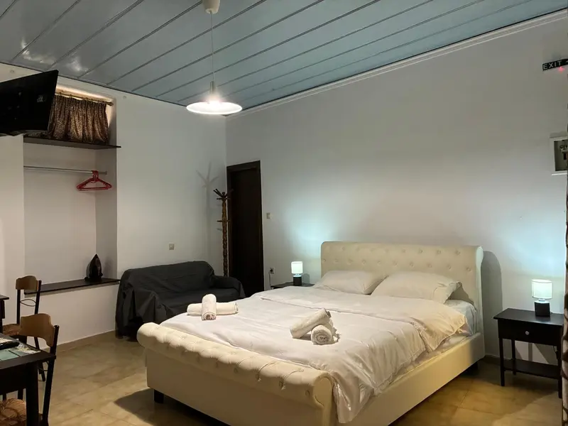 Une chambre lumineuse avec un lit double et un coin salon.
