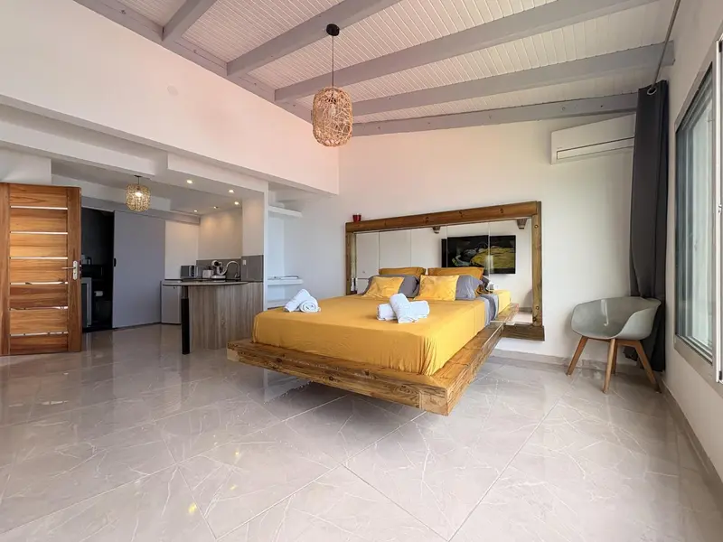 Une chambre lumineuse avec un grand lit et un espace détente.