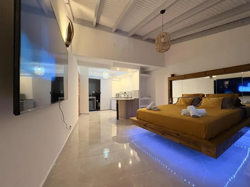 Une chambre lumineuse avec un grand lit et un éclairage d'ambiance.