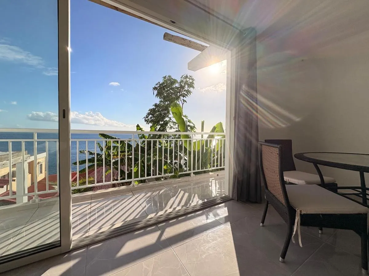 Vue sur la mer depuis une terrasse ensoleillée.