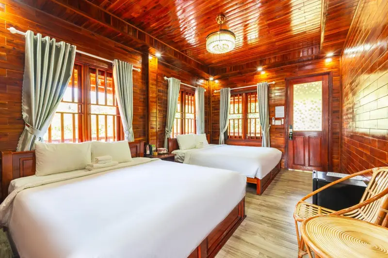 Chambre avec deux lits simples et décoration en bois.