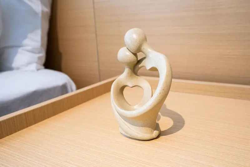 Une sculpture décorative repose sur une table de chevet.