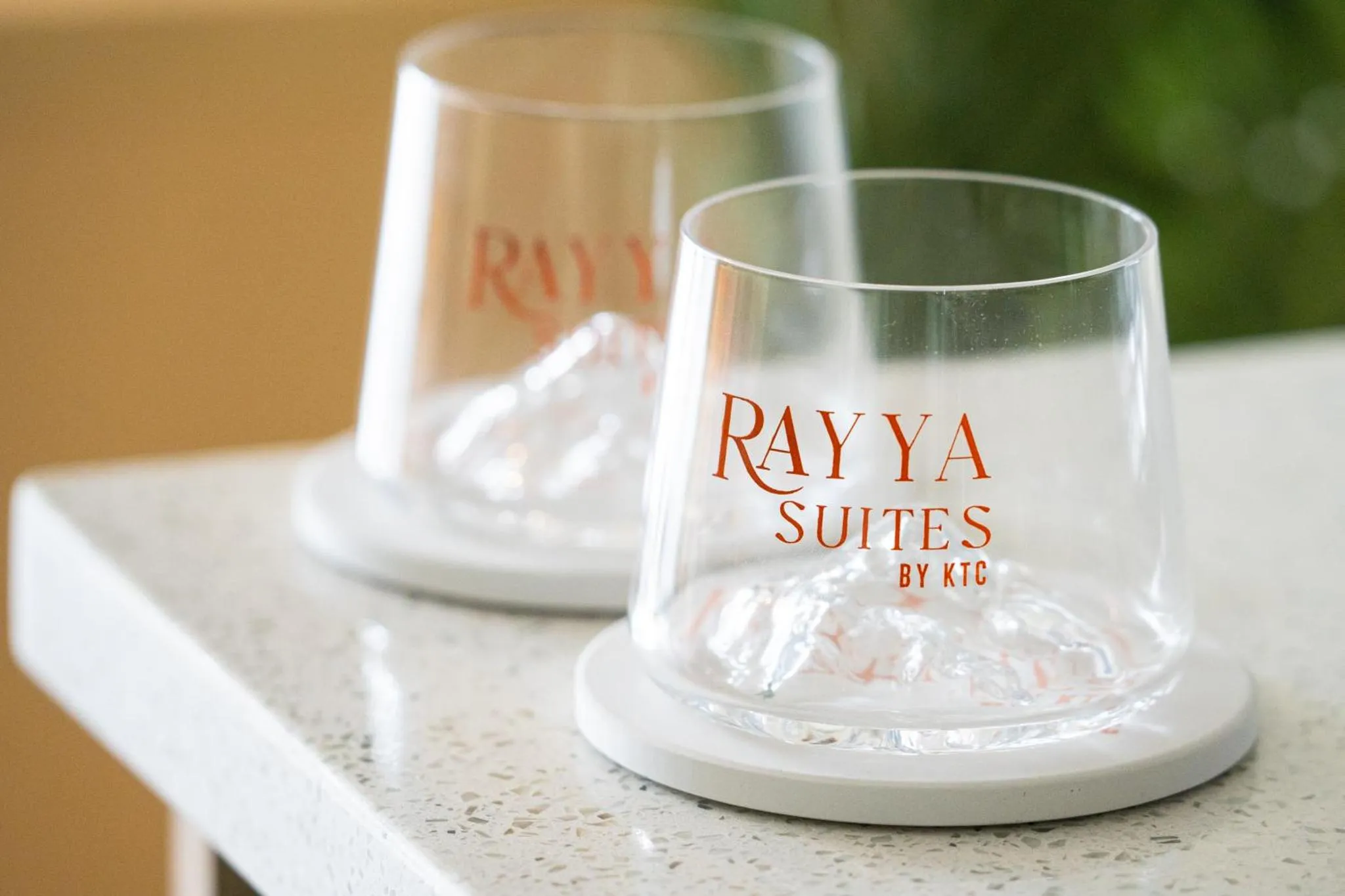Deux verres à eau gravés d'un logo sont posés sur une surface claire.