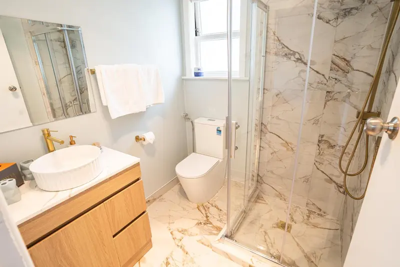Une salle de bain moderne avec douche à l'italienne et lavabo sur meuble.