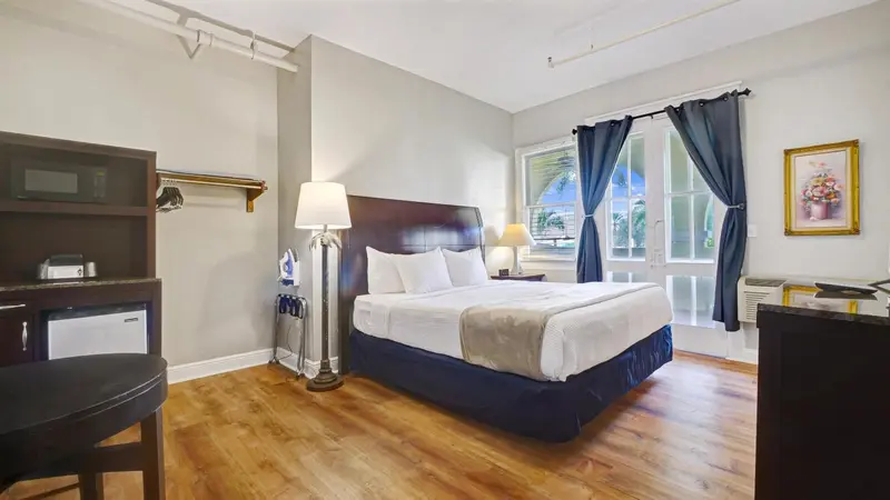 Une chambre lumineuse avec un lit double et un bureau.