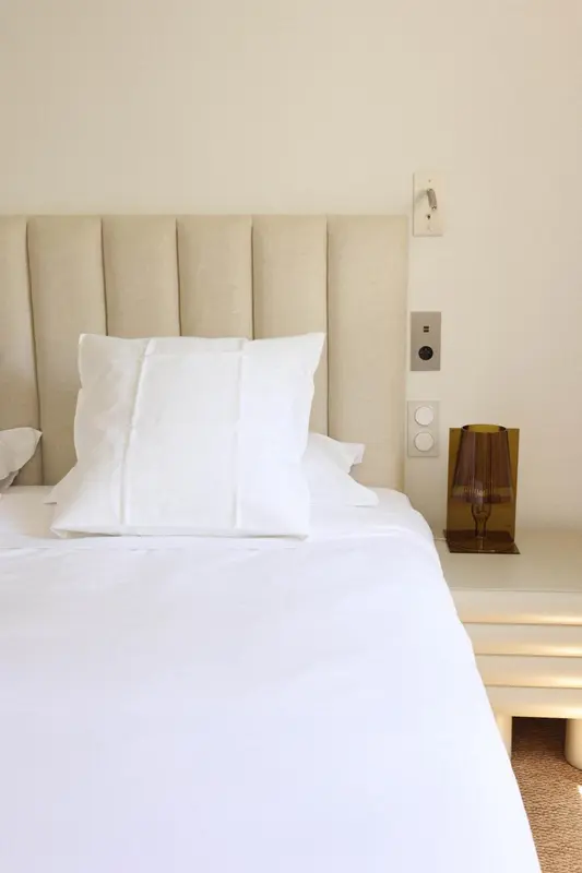 Un lit blanc avec des oreillers moelleux dans une chambre lumineuse.
