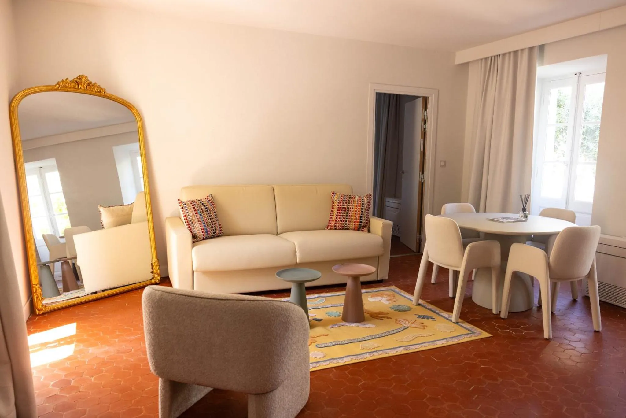 Un salon clair avec un canapé beige et une table à manger.