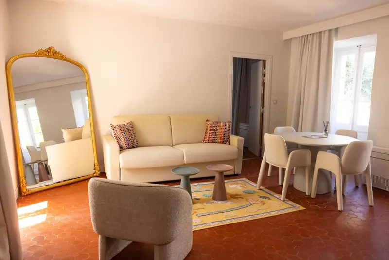 Un salon clair avec un canapé beige et une table à manger.