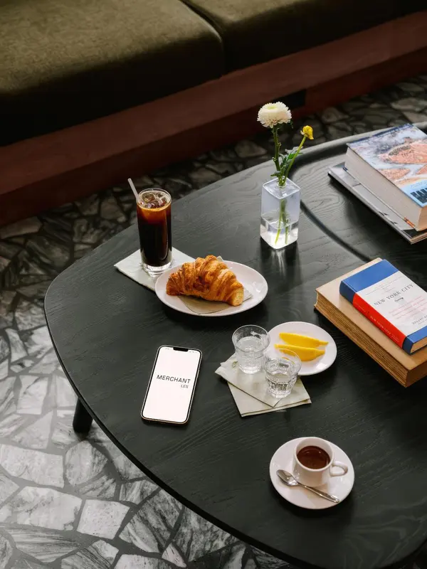 Une table basse présente une boisson, une viennoiserie et des livres.