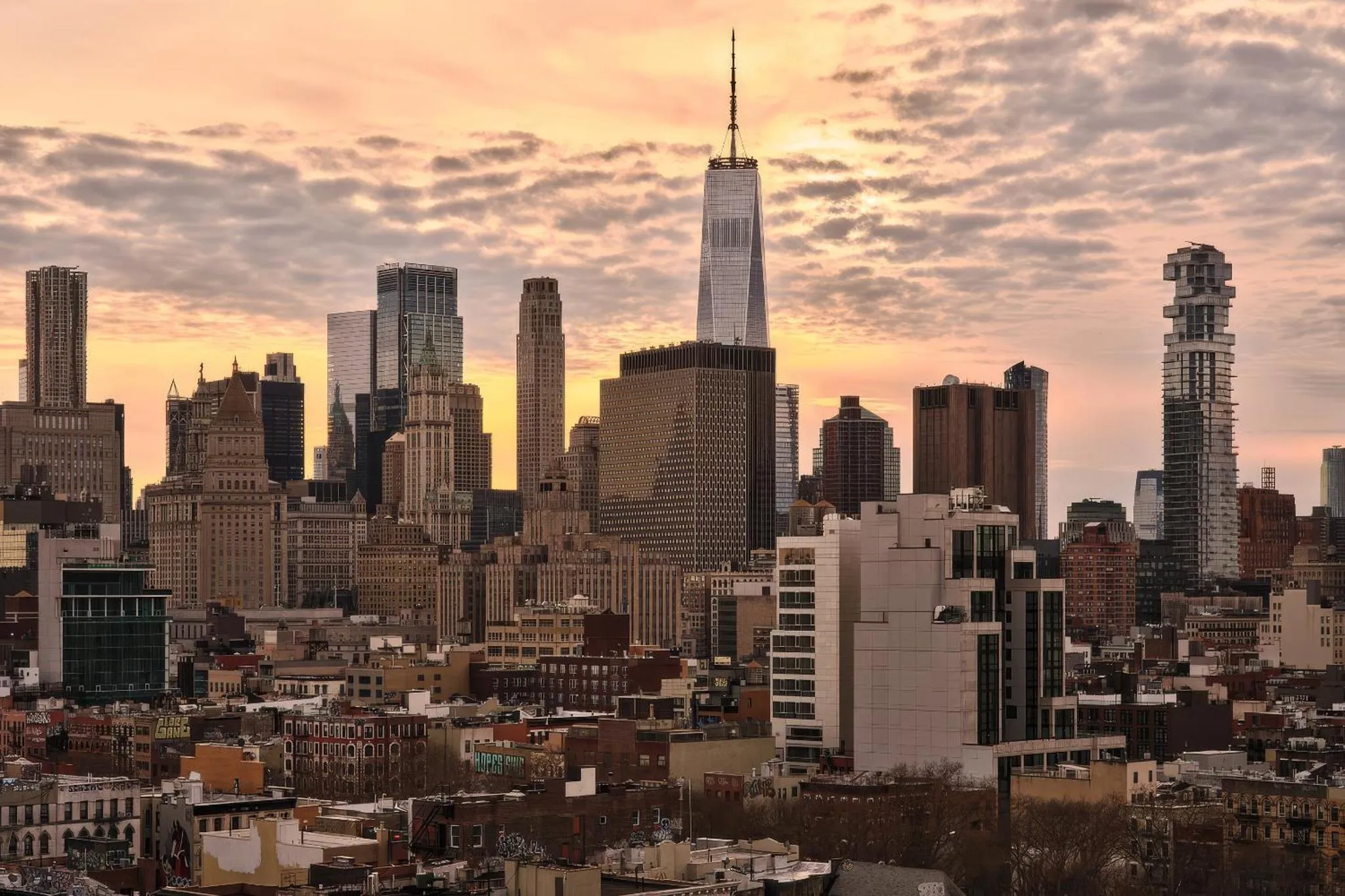 Vue urbaine au coucher du soleil sur une ville avec de nombreux gratte-ciel.