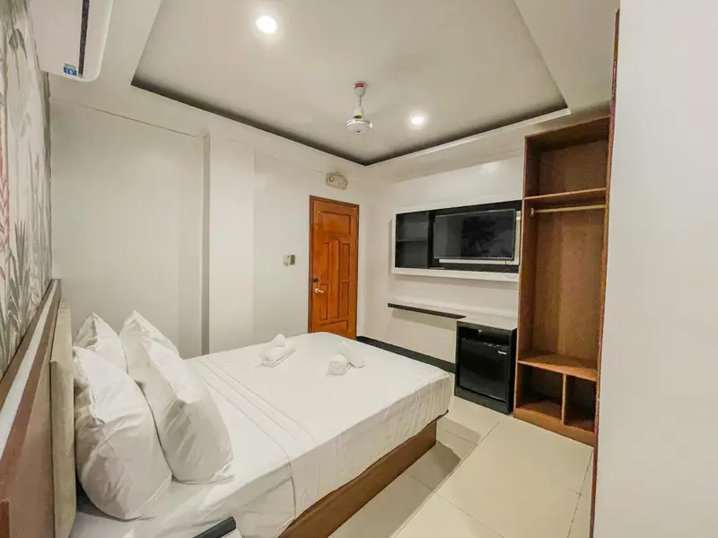 Une chambre lumineuse avec un grand lit et un placard intégré.
