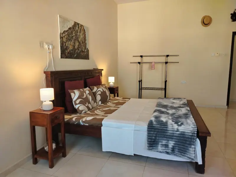 Une chambre lumineuse avec un grand lit et une décoration murale.