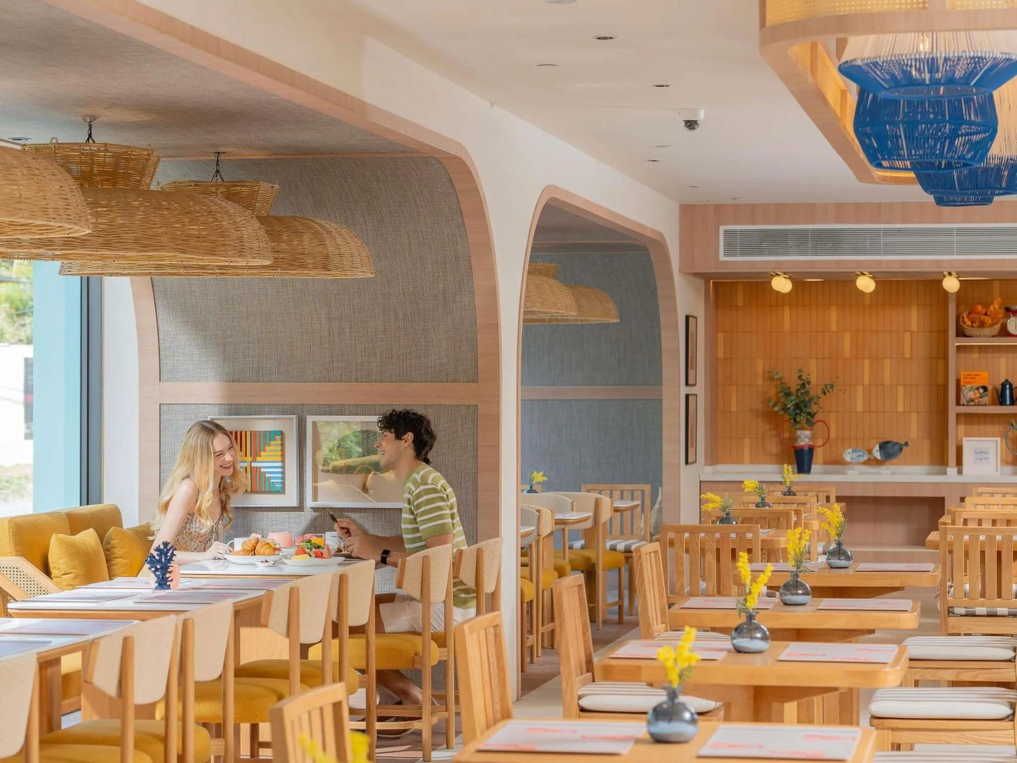 Une salle lumineuse avec des tables et des chaises accueillent des clients.