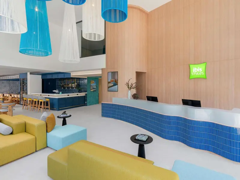 Un hall d'accueil moderne avec un comptoir incurvé et des canapés colorés.
