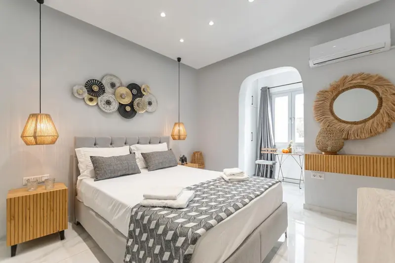 Une chambre lumineuse avec un grand lit et une décoration murale originale.