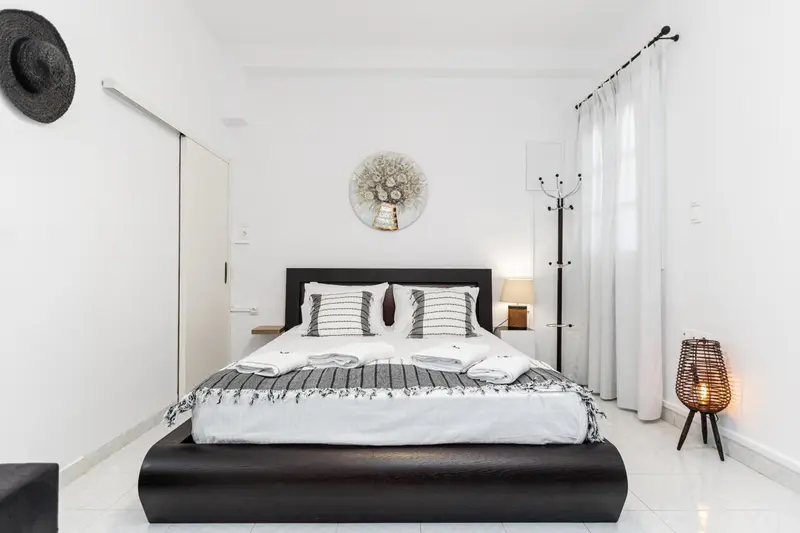 Une chambre lumineuse avec un grand lit recouvert d'une courtepointe décorative.