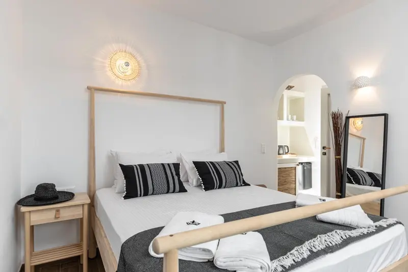 Une chambre lumineuse avec un grand lit et une décoration sobre.