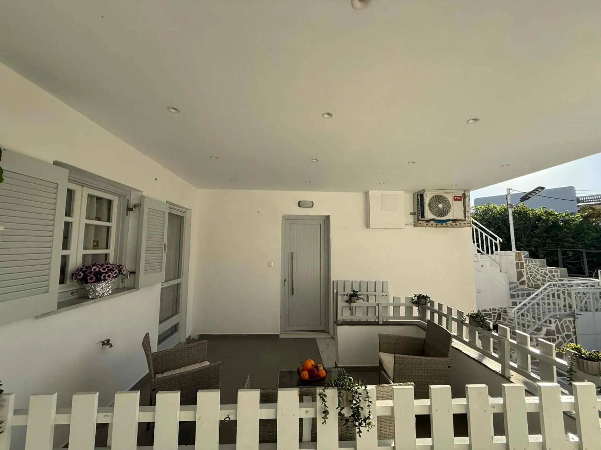 Terrasse ombragée avec mobilier d'extérieur et plantes.