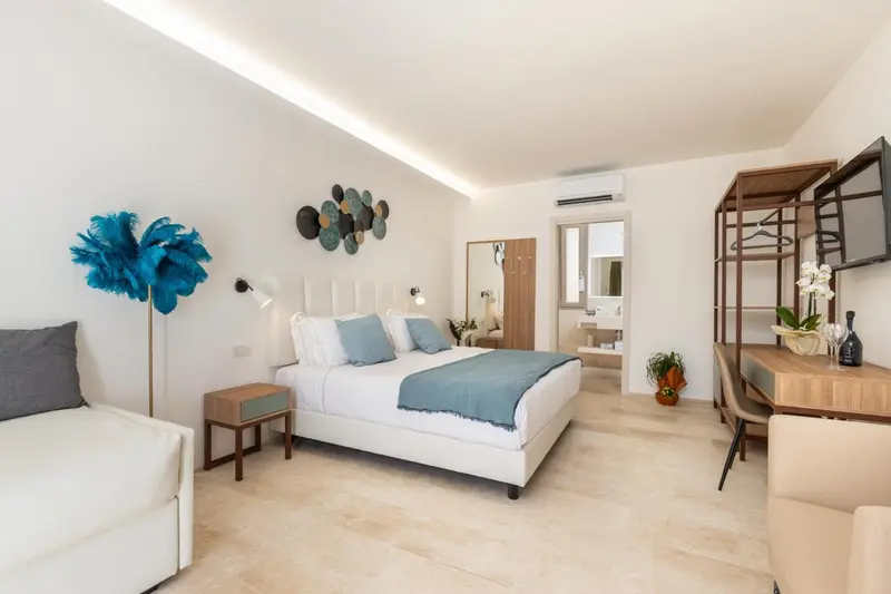 Chambre lumineuse avec un grand lit et un espace détente.