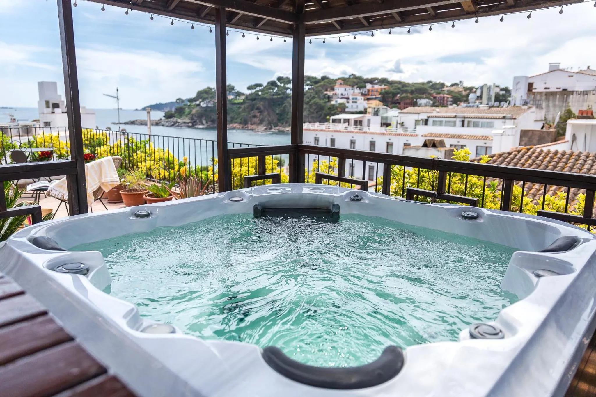 Un jacuzzi extérieur offre une vue sur la mer et les bâtiments environnants.