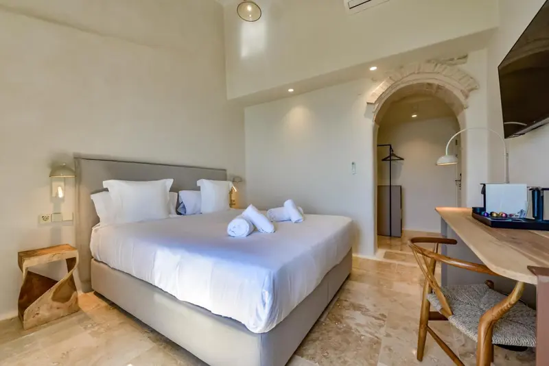Une chambre lumineuse avec un grand lit et un espace détente.