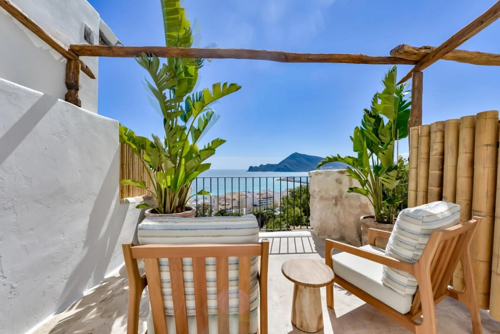 Terrasse aménagée avec mobilier en bois et vue sur la mer.