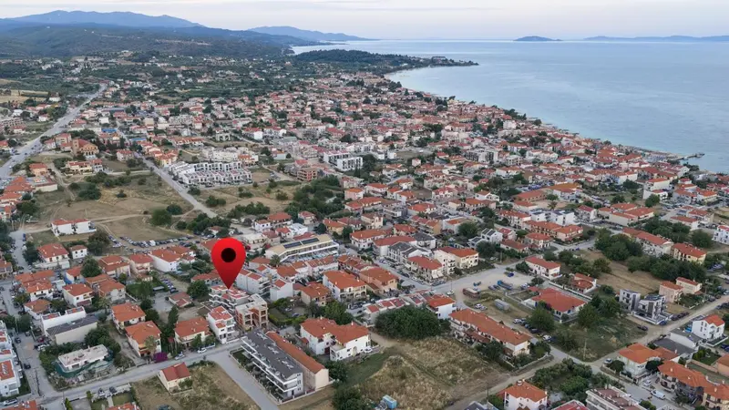 Vue aérienne d'une ville côtière avec des bâtiments et une végétation luxuriante.