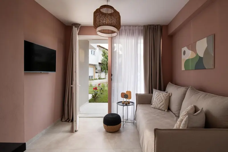 Un salon clair avec un canapé et un accès à une terrasse.