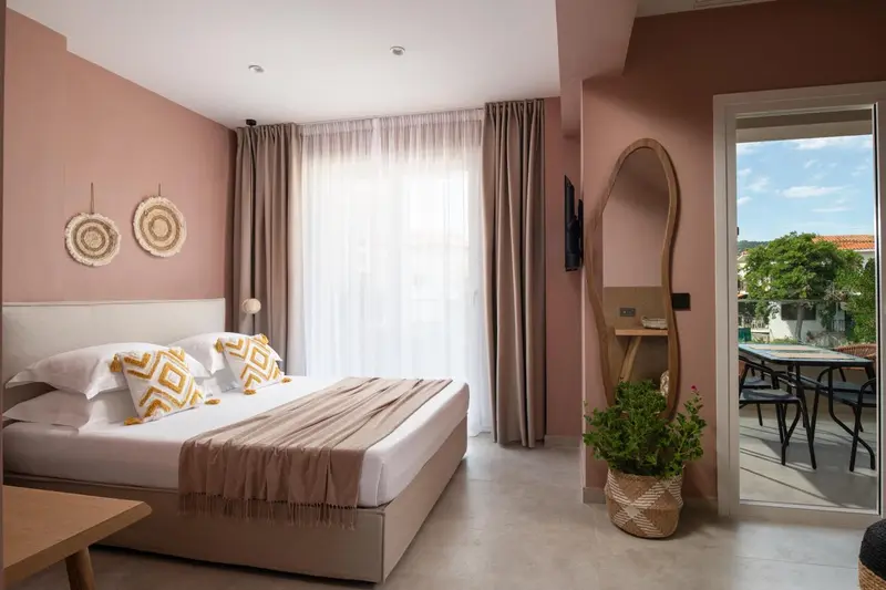 Chambre lumineuse avec un grand lit et une décoration sobre.