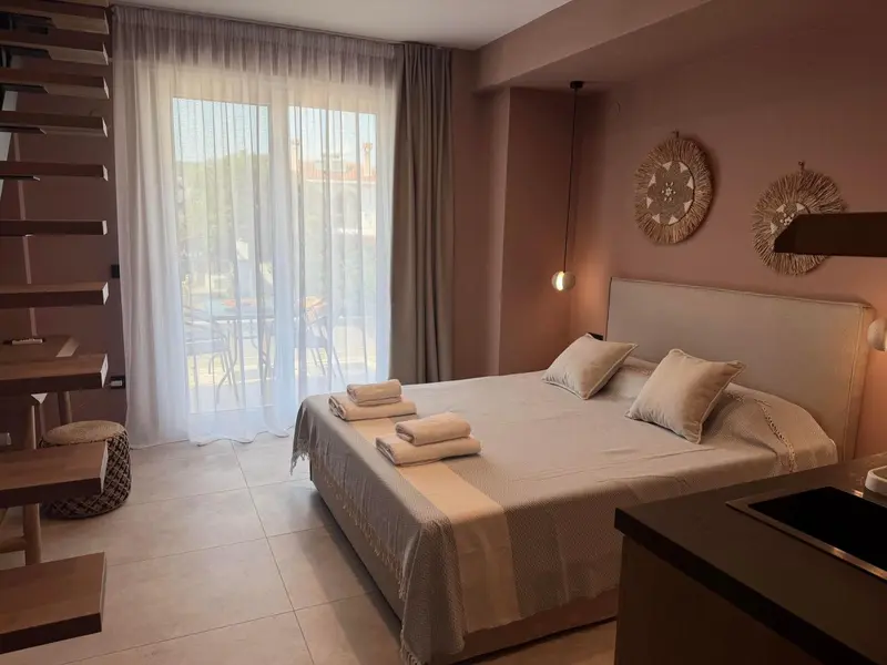 Une chambre lumineuse avec un grand lit et un accès à une terrasse.