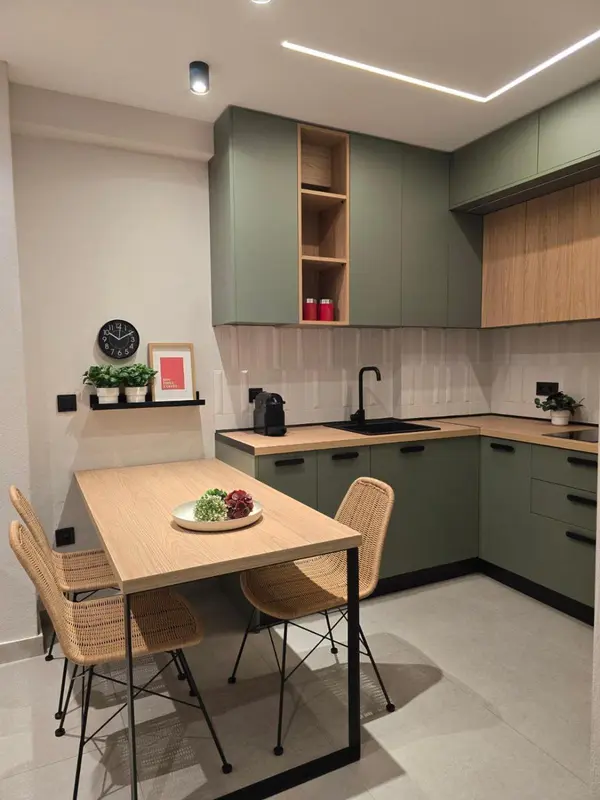 Une cuisine moderne avec un coin repas en bois et des chaises en rotin.