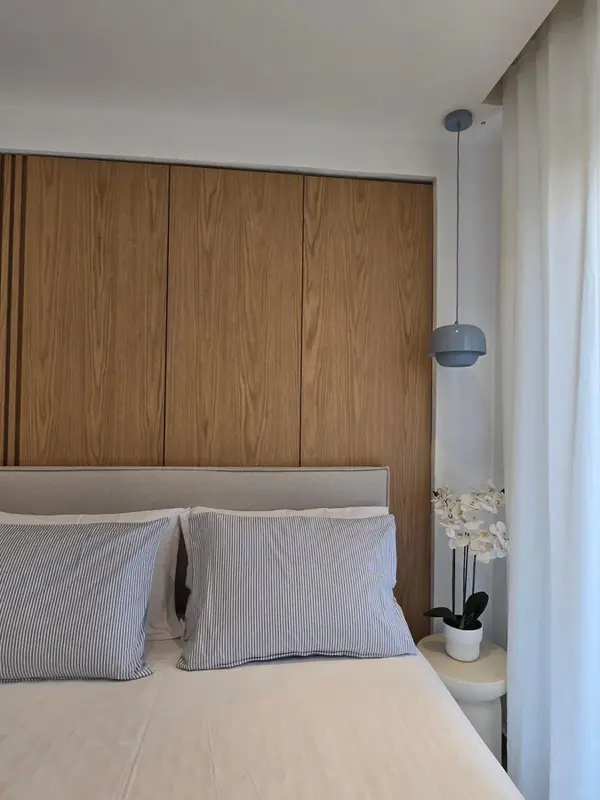 Un lit avec des oreillers rayés dans une chambre lumineuse.