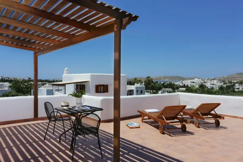 Terrasse aménagée avec mobilier de jardin et vue sur la ville.