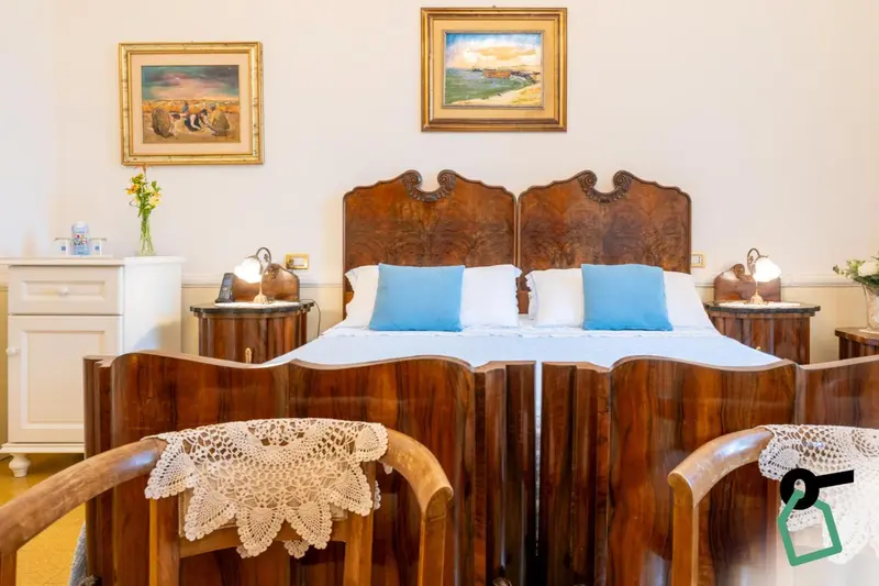 Une chambre à coucher avec un grand lit en bois sculpté et des tables de chevet.
