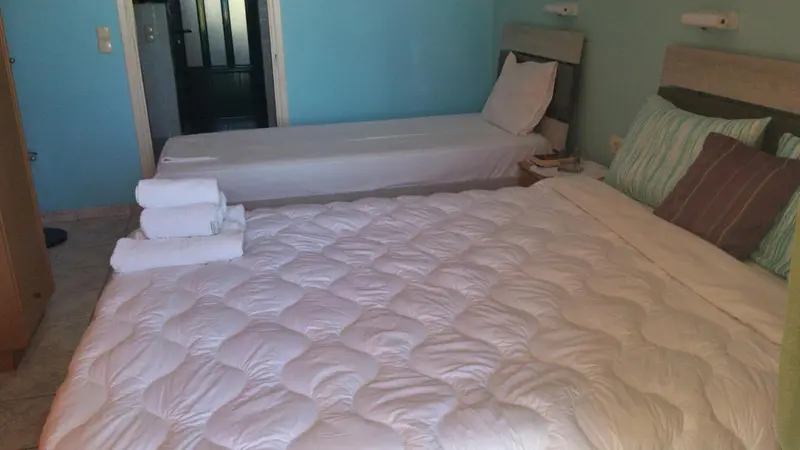 Une chambre avec deux lits simples et une décoration sobre.