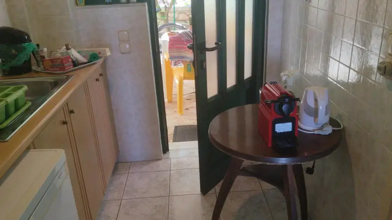 Une cuisine ouverte sur un espace extérieur avec une table et des chaises.