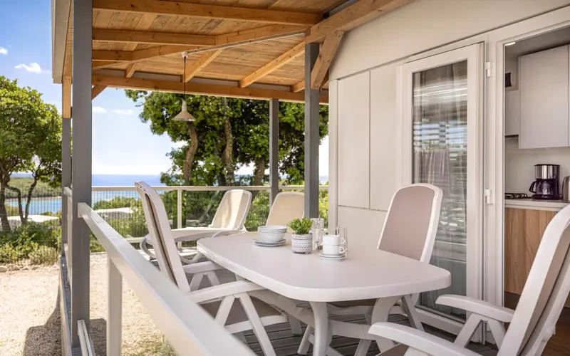 Terrasse aménagée avec table et chaises, donnant sur une vue dégagée.