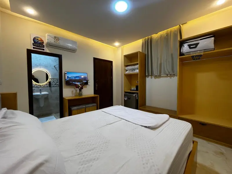 Une chambre lumineuse avec un grand lit recouvert de draps blancs.