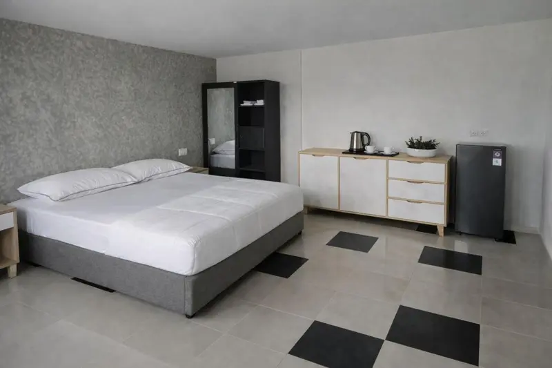 Une chambre lumineuse avec un grand lit et un meuble de rangement.