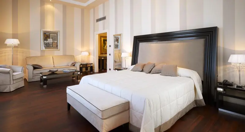 Une chambre spacieuse avec un grand lit et un coin salon.