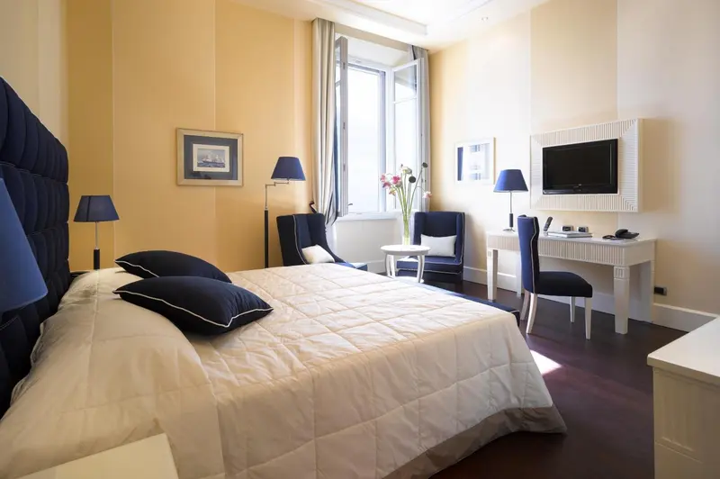 Une chambre lumineuse avec un grand lit et un coin salon.